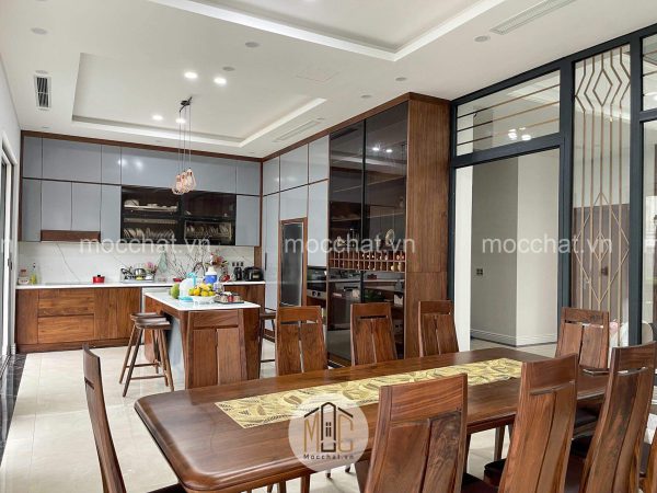 Không gian phòng bếp gỗ óc chó gồm bàn ăn gỗ óc chó tủ bếp gỗ óc chó và tủ rượu gỗ óc chó