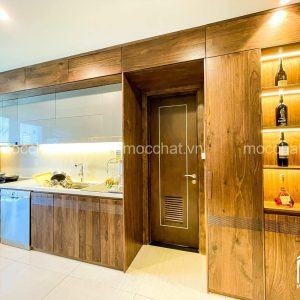 Tủ bếp gỗ óc chó kết hợp liền mạch với hệ cửa ra vào và kệ tủ rượu trang trí