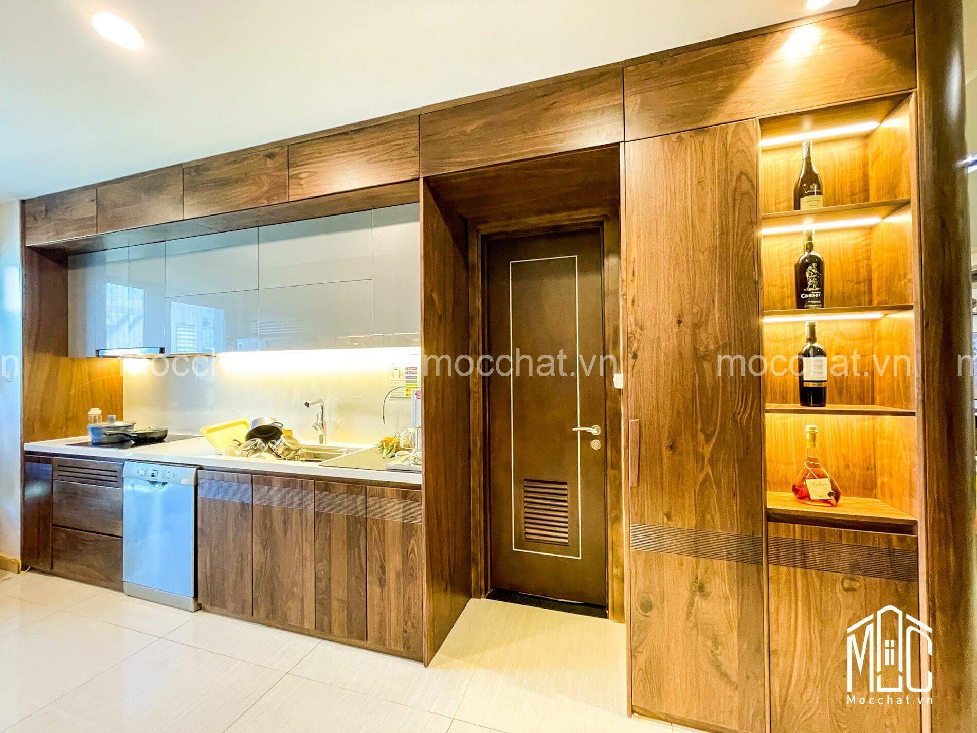 Tủ bếp gỗ óc chó kết hợp liền mạch với hệ cửa ra vào và kệ tủ rượu trang trí