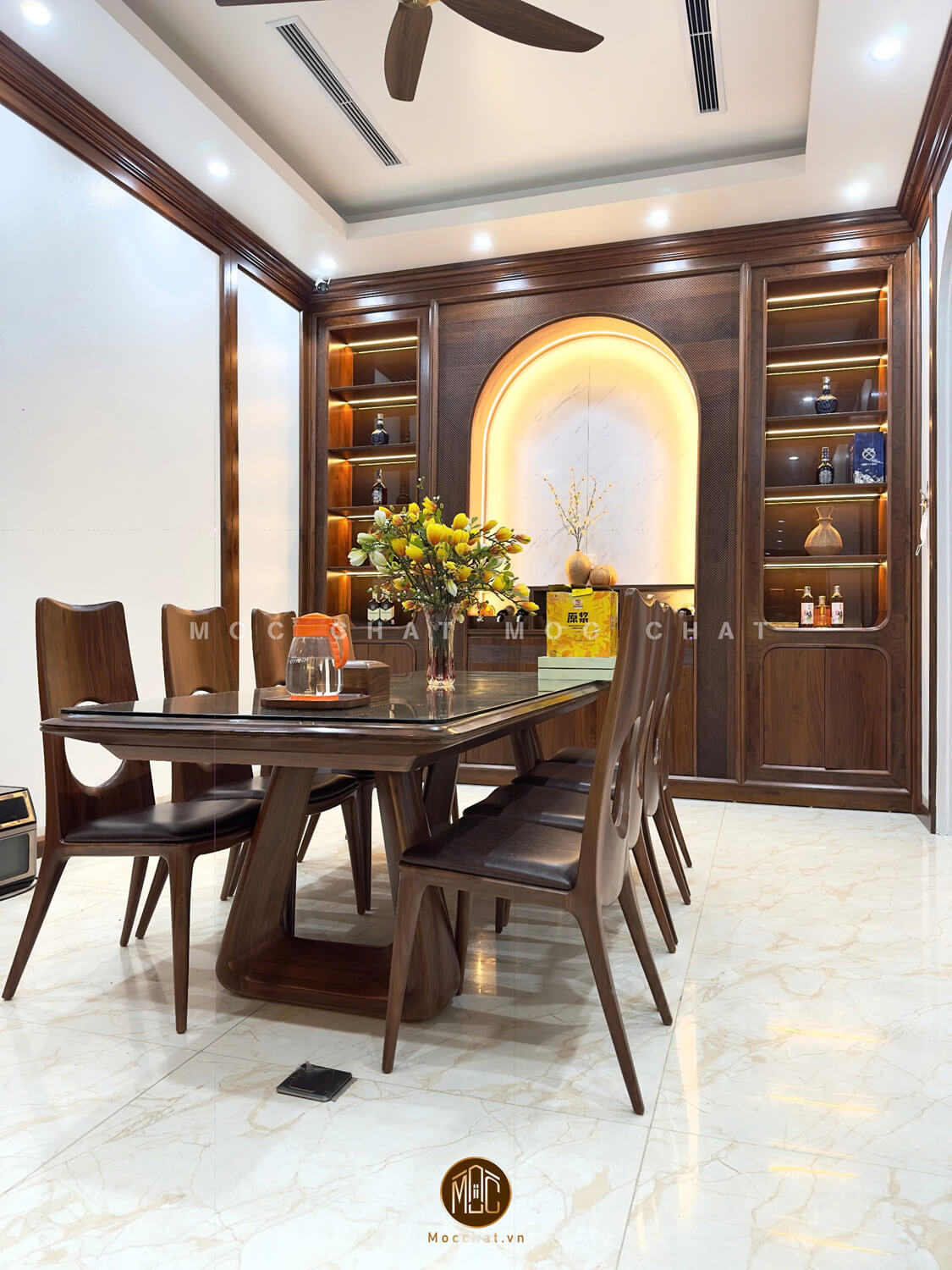 Bộ bàn ăn gỗ óc chó 8 ghế với bàn mặt kính cường lực và hệ tủ rượu kịch trần tạo không gian ăn uống sang trọng và tinh tế