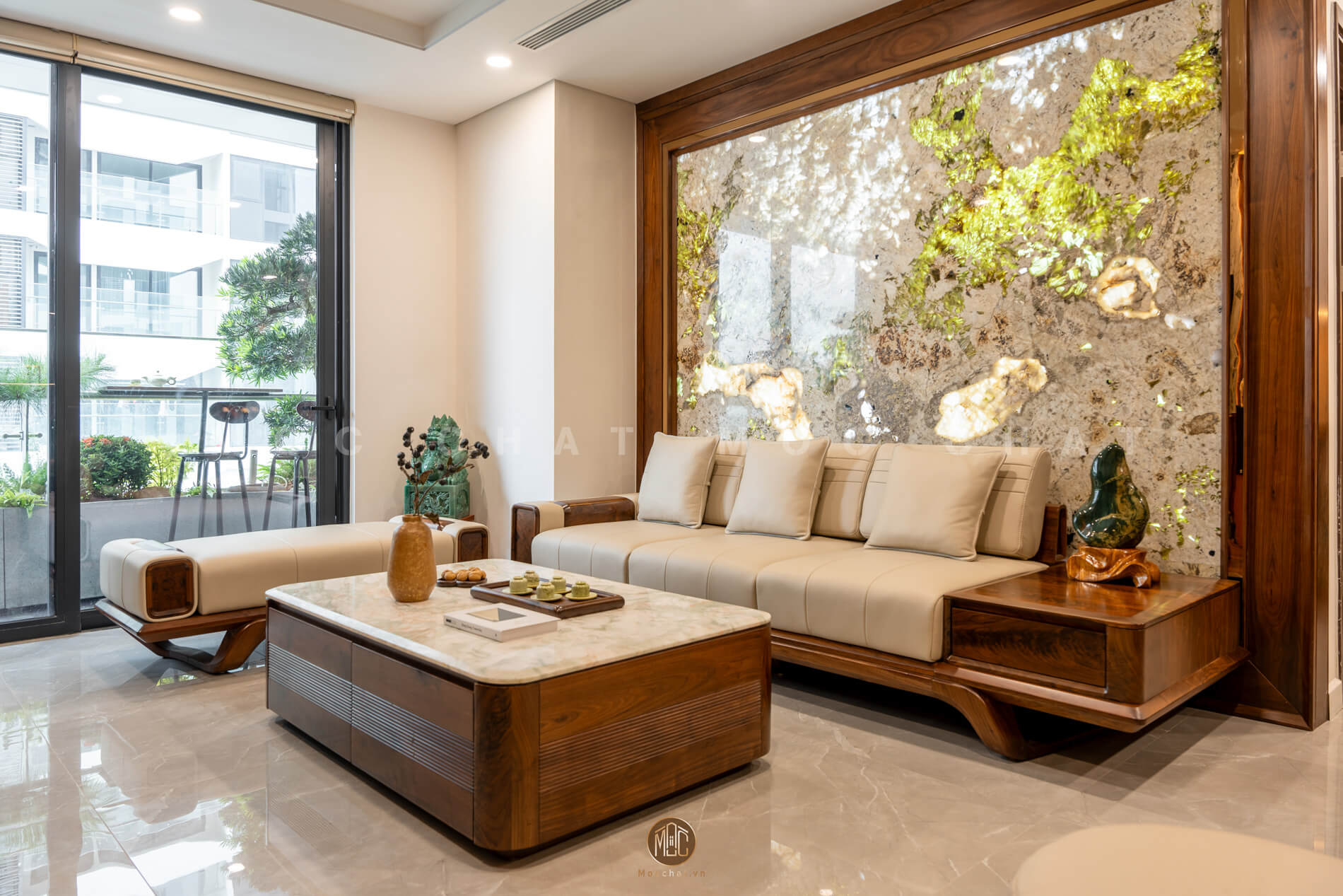 Phòng khách hiện đại nổi bật với bộ sofa gỗ óc chó tự nhiên, bàn trà gỗ óc chó mặt đá và vách trang trí đá cao cấp, mang đến không gian đẳng cấp, tinh tế.